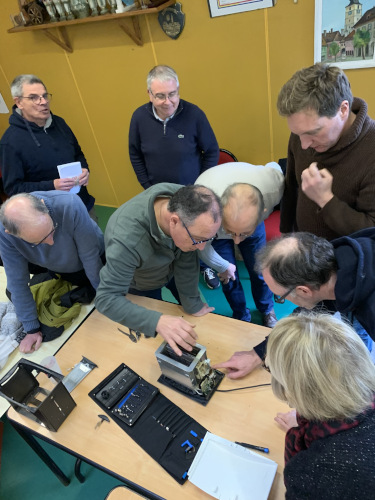 photo d'un groupe de personnes auscultant un grille pain.